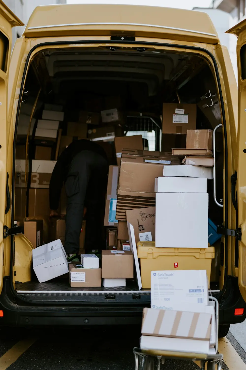 Person loading cardboard boxes into a van