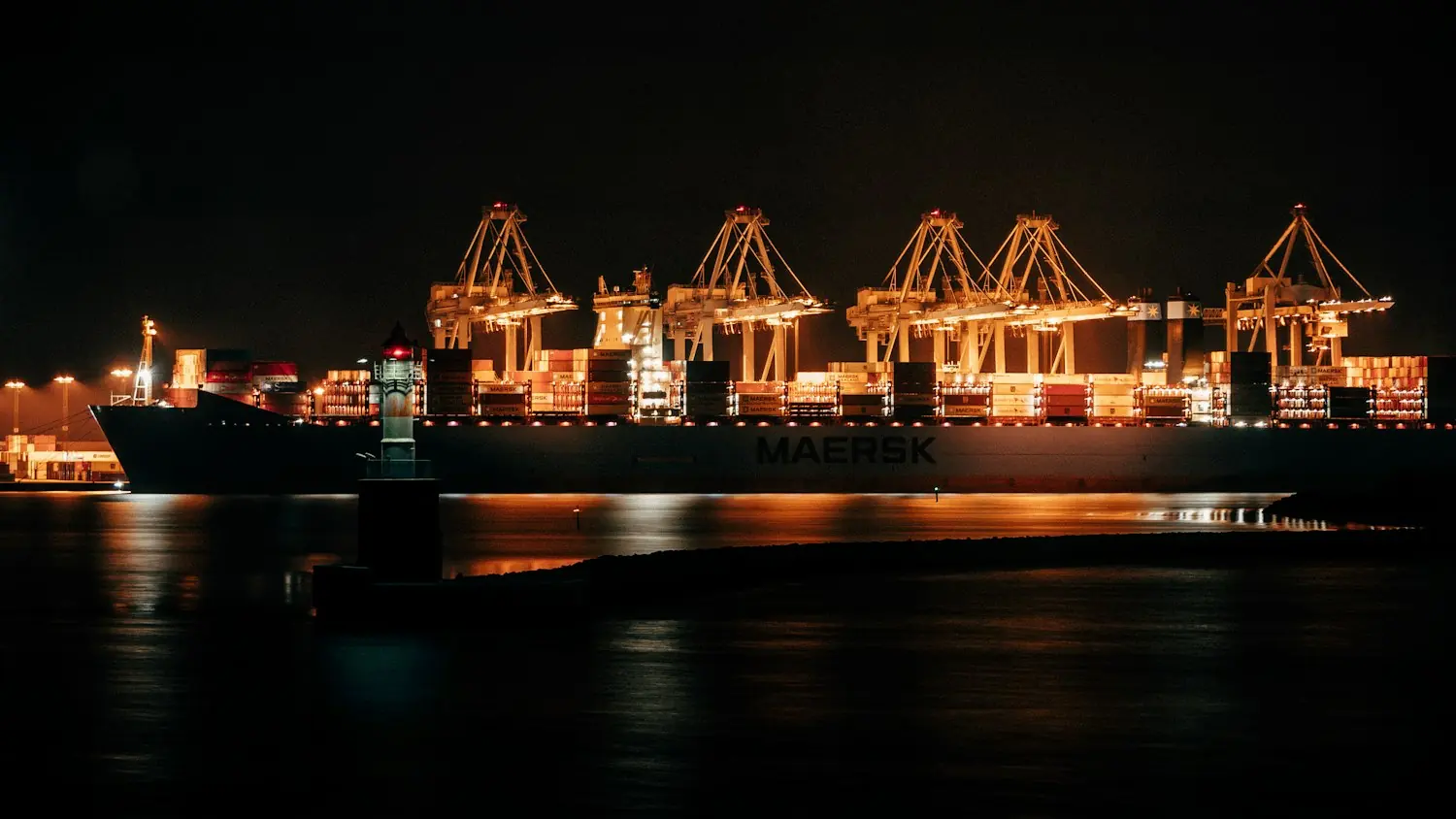 Cranes and container ships at a night port