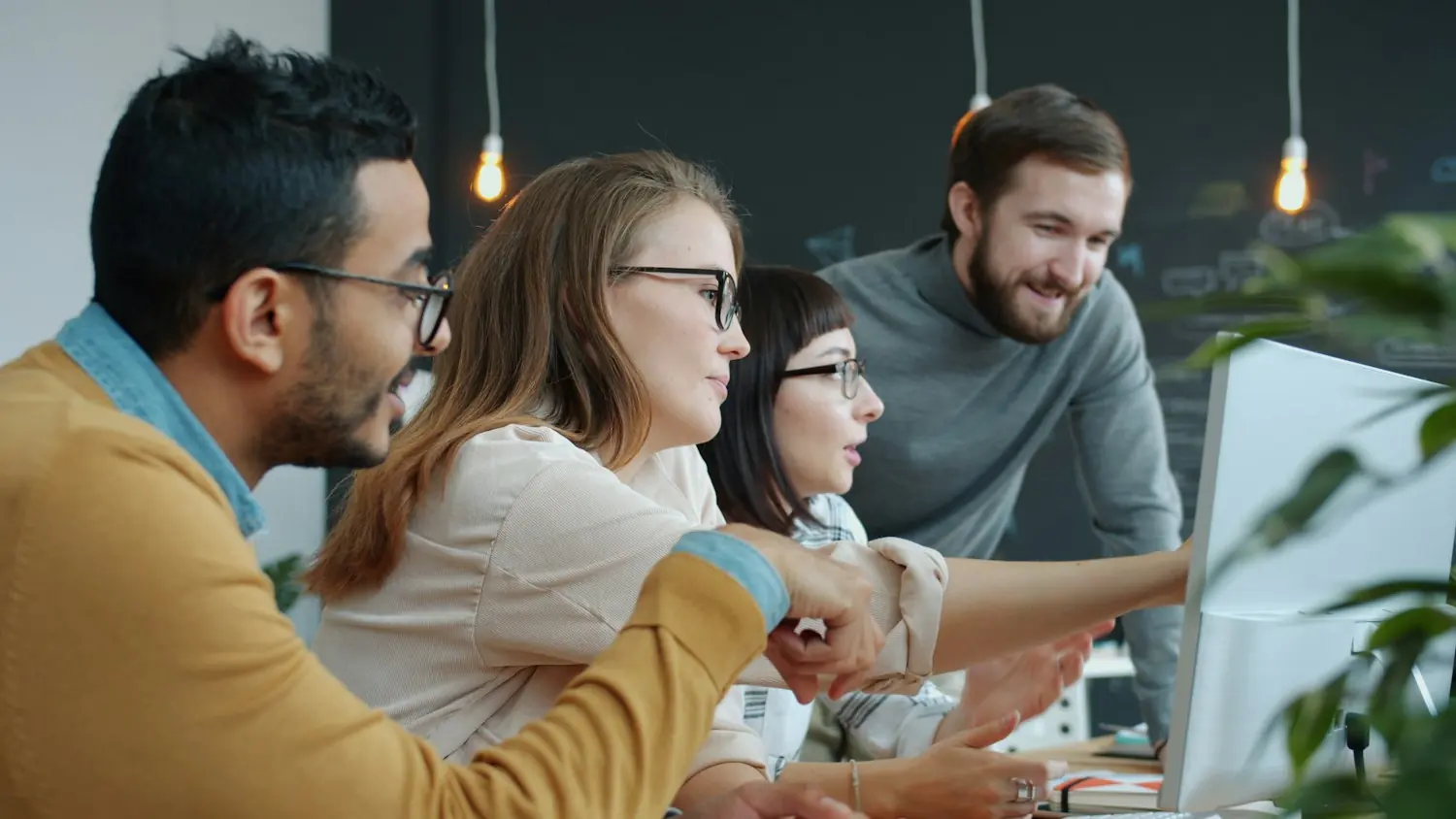 Team collaborating around a screen